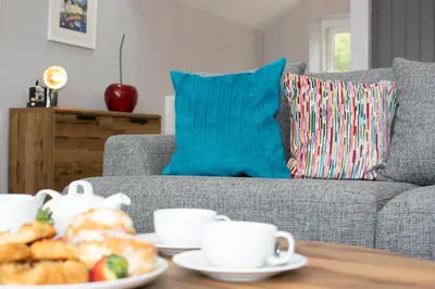 a living room with a couch and a table with coffee cups at 1 Bed in Fowey oc-p00802 in Fowey