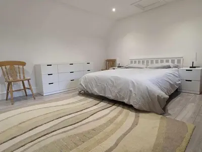 a white bedroom with a bed and a rug at Truckle - Treknow, Tintagel - Bungalow in North Cornwall (Sleeps 5 - 7) in Treknow