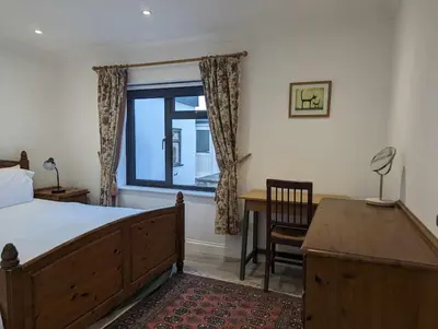 a bedroom with a bed and a desk and a window at Truckle - Treknow, Tintagel - Bungalow in North Cornwall (Sleeps 5 - 7) in Treknow