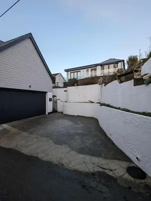 a parking lot with a garage and a building at Truckle - Treknow, Tintagel - Bungalow in North Cornwall (Sleeps 5 - 7) in Treknow