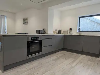 a kitchen with stainless steel appliances and a window at Truckle - Treknow, Tintagel - Bungalow in North Cornwall (Sleeps 5 - 7) in Treknow