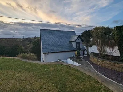 a small white house with a pitched roof at Truckle - Treknow, Tintagel - Bungalow in North Cornwall (Sleeps 5 - 7) in Treknow