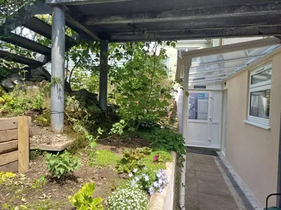 a house with a pathway leading to a white door at The Conifers 3 Room Small but Stylish Self Catering Bedsit Flat in Nature Reserve Free Eden taxi b4 9pm no lounge in Par