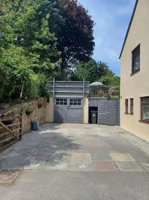 a garage with a gate and a building at The Conifers 3 Room Small but Stylish Self Catering Bedsit Flat in Nature Reserve Free Eden taxi b4 9pm no lounge in Par