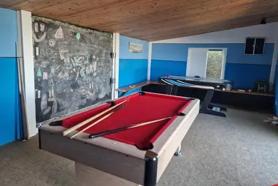 a room with a pool table in front of a wall at Treworgie Barton - Warner in Bude