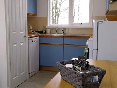 a kitchen with a white refrigerator and a basket on a table at Three bed Holiday Home in Hayle