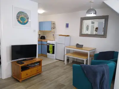 a living room with a television and a kitchen at Three bed Holiday Home in Hayle