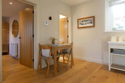a room with a table and chairs and a window at Secluded woodland annex between Mylor and Flushing in Falmouth