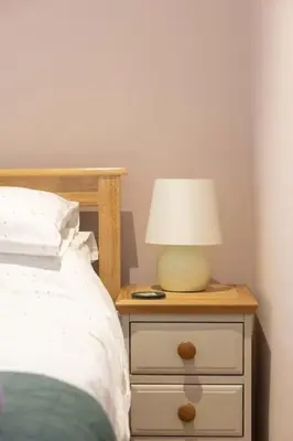 a lamp on a night stand next to a bed at Secluded woodland annex between Mylor and Flushing in Falmouth