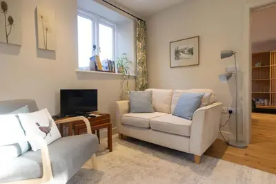 a living room with a couch and a chair at Secluded woodland annex between Mylor and Flushing in Falmouth