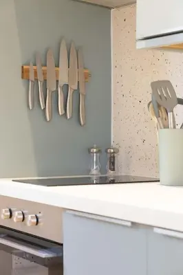 a kitchen with knives hanging on a wall at Secluded woodland annex between Mylor and Flushing in Falmouth