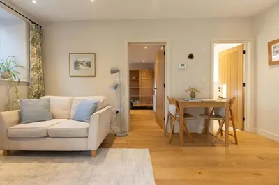 a living room with a couch and a table at Secluded woodland annex between Mylor and Flushing in Falmouth