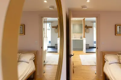 a room with two beds and a mirror at Secluded woodland annex between Mylor and Flushing in Falmouth