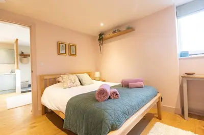 a bedroom with a bed with two hats on it at Secluded woodland annex between Mylor and Flushing in Falmouth