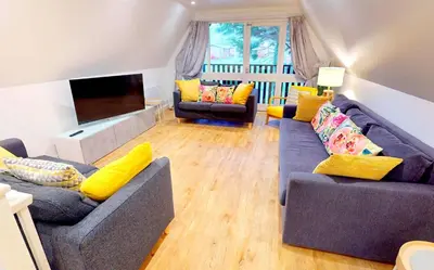 a living room with two couches and a flat screen tv at St Ives Fir Tree Lodge in St Ives