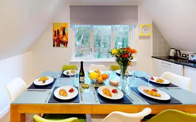 a dining room table with plates of fruit on it at St Ives Fir Tree Lodge in St Ives