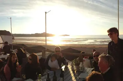 a group of people sitting at a table on the beach at Wonderful Beach House Just 250m From The Sea in Newquay