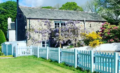 an old stone house with a white picket fence at Goodrevy Barn in Launceston