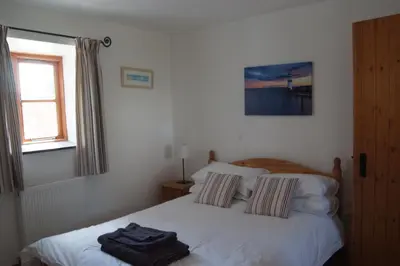 a bedroom with a bed with two towels on it at Goodrevy Barn in Launceston