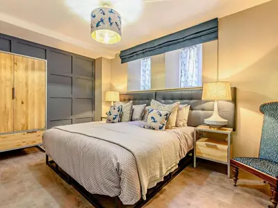 a bedroom with a bed and a chair and a window at 3 Bed in Newquay oc-90068 in Newquay