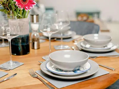 a wooden table with plates and bowls and wine glasses at 3 Bed in Newquay oc-90070 in Newquay