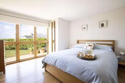 a bedroom with a bed with a tray of food on it at Sandbar in Saint Just in Roseland