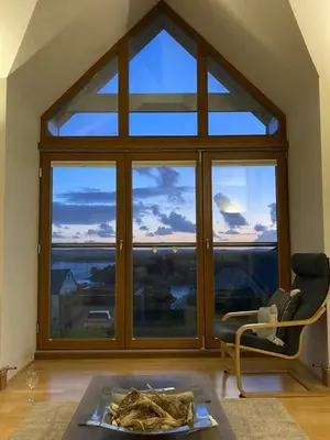 a living room with a large window with a view at Sandbar in Saint Just in Roseland
