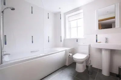 a white bathroom with a tub and a toilet and a sink at Sandbar in Saint Just in Roseland