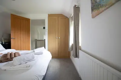 a bedroom with two beds with towels on them at Cornish Cottage - Sleeps 8/9 in Helston