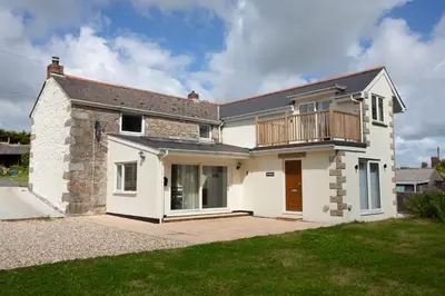 a large white house with a balcony on it at Cornish Cottage - Sleeps 8/9 in Helston