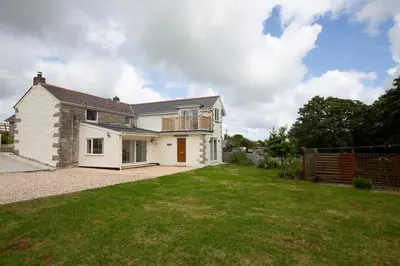 a house with a large yard in front of it at Cornish Cottage - Sleeps 8/9 in Helston