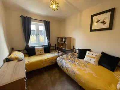 a bedroom with two beds and a window at Bumblebee Barn, Luxury contemporary holiday home in Perranporth