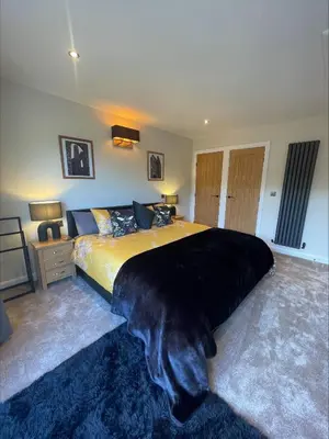 a bedroom with a large bed with a black blanket at Bumblebee Barn, Luxury contemporary holiday home in Perranporth
