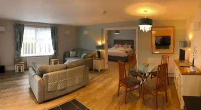 a living room with a couch and a bed and a table at Beacon Hotel Self Catering Apartment in St. Agnes