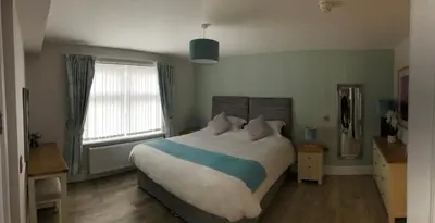 a bedroom with a large bed and a window at Beacon Hotel Self Catering Apartment in St. Agnes
