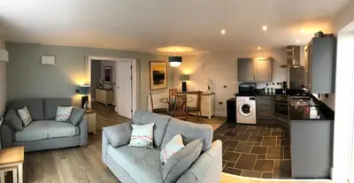 a living room with a couch and a kitchen at Beacon Hotel Self Catering Apartment in St. Agnes