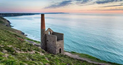 an old building on a hill next to the ocean at Beacon Hotel Self Catering Apartment in St. Agnes