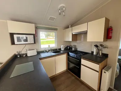 a small kitchen with a stove and a sink at Willows Way Newquay Holiday Park in Newquay