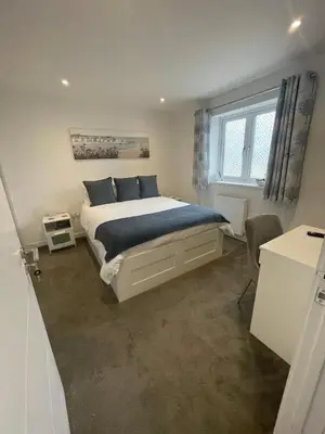 a bedroom with a bed with blue pillows and a window at Bed and breakfast near Truro and the A30 in Truro