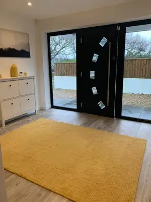 a living room with a door with a yellow rug at Bed and breakfast near Truro and the A30 in Truro