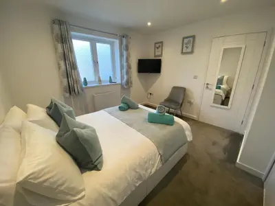 a bedroom with a bed with a chair and a window at Bed and breakfast near Truro and the A30 in Truro