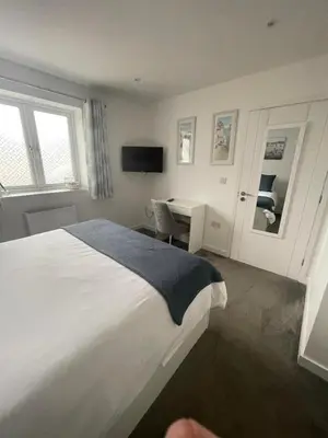 a hotel room with a bed and a desk and a television at Bed and breakfast near Truro and the A30 in Truro