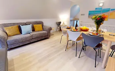 a living room with a couch and a table and chairs at St Ives Bluebell Cottage in St Ives