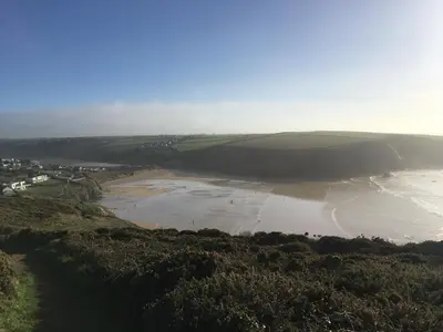 an aerial view of a beach and a body of water at Cosy Cornish cottage with rural views in Newquay
