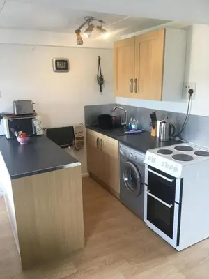 a kitchen with a stove and a dishwasher at Cosy Cornish cottage with rural views in Newquay