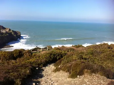 a bench sitting on a hill overlooking the ocean at Number Six in St. Agnes