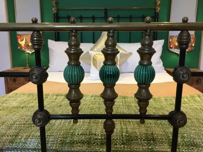 a bed with a green and black bed frame at Number Six in St. Agnes