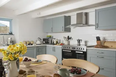 a kitchen with a table and chairs and a stove at School Cottage, Marazion in Marazion