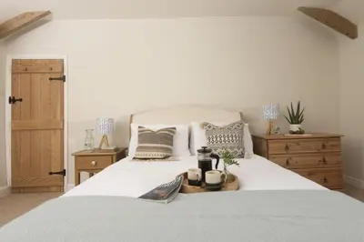 a bedroom with a white bed with a tray on it at School Cottage, Marazion in Marazion
