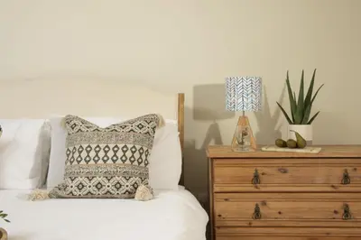 a bed with a pillow and a lamp on a dresser at School Cottage, Marazion in Marazion